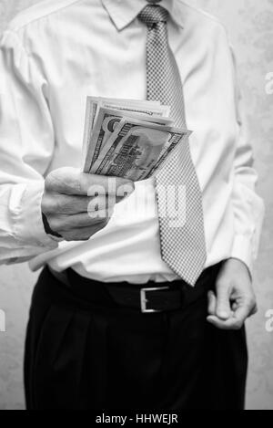 Corrupted businessman, or politician, offering a Dollar banknotes bribe Stock Photo