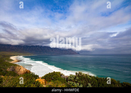 False Bay beach along Clarence Drive with view of Kogelberg mountains covered in clouds Stock Photo