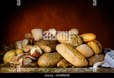different kinds of breads and buns in a rustic setup. Stock Photo