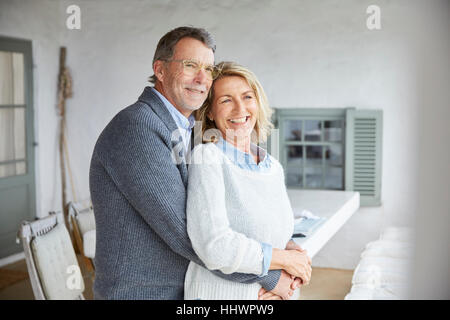 Smiling affectionate couple hugging on patio Stock Photo