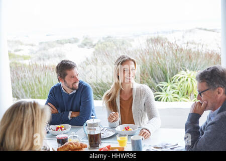 Couples enjoying breakfast on beach patio Stock Photo