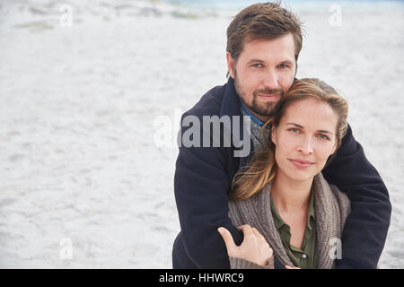 Portrait serene affectionate couple hugging on beach Stock Photo