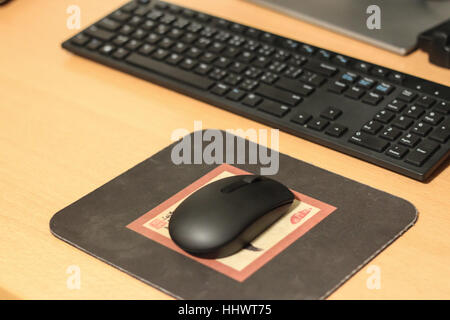 Wireless black stylish computer mouse lying on table Stock Photo