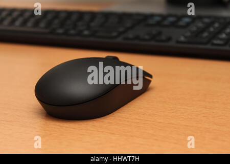 Wireless black stylish computer mouse lying on table Stock Photo