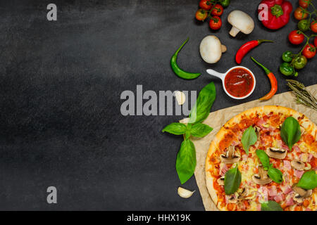 Baked Pizza with tomato sauce, cheese, mushrooms and vegetables on a dark background and Copy Space Area Stock Photo