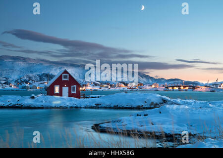 Solitary typical Norwegian red wooden house in the snow at sunset in winter Stock Photo