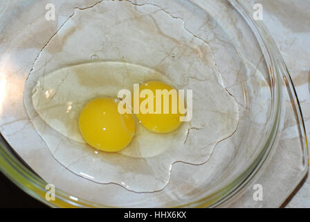 Broken yellow chicken eggs on a dish Stock Photo