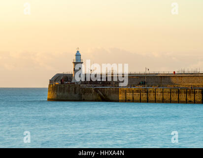 Folkestone lighthouse and harbour arm at sunrise, Kent. Stock Photo