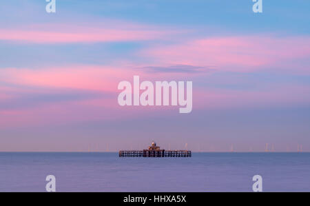 Sunset behind the abandoned pier head at Herne Bay on the Kent coast. Stock Photo