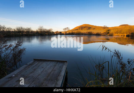 Summerhouse Hill on the Kent Downs reflected in Beachborough ponds at dawn. Stock Photo