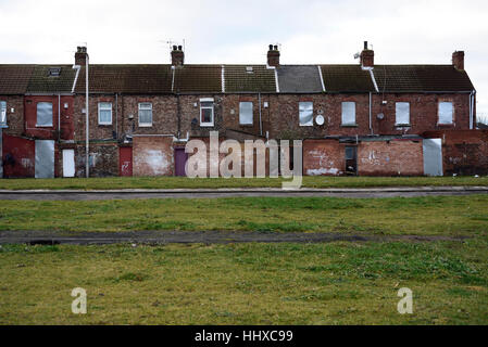 Houses in central Middlesbrough boarded up nprior to demolition with a grassed-over area marking site of other demolished homes Stock Photo