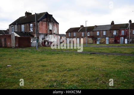 Homes in central Middlesbrough boarded up prior to demolition with a grassed-over area where other homes used to be. Stock Photo