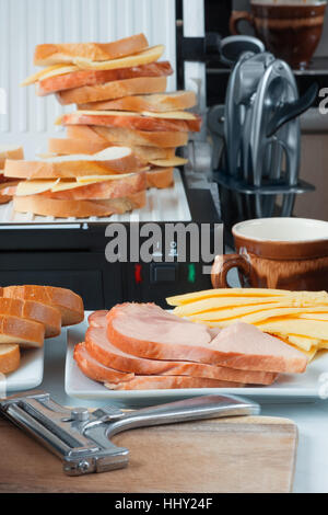 Hot cheese and ham sandwiches, a  slicer, cup of coffee slices Stock Photo