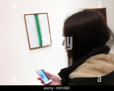 Visitor uses a smartphone in front of the painting Green Line (1917) by Russian avant-garde painter Olga Rozanova displayed at the exhibition Icons of Modern Art from the Shchukin Collection in the Fondation Louis Vuitton in Paris, France. The exhibition runs till 5 March 2017. Stock Photo