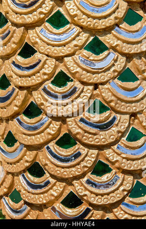 Close-up view decoration Buddhist temple. Gilded scales statue of a dragon in a Buddhist monastery, Thailand Stock Photo