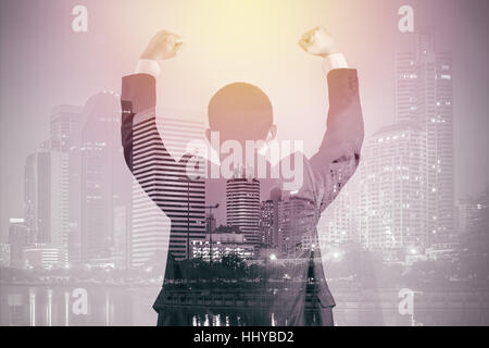 Business success concept shown by double exposure of business in suit with urban city background. Stock Photo
