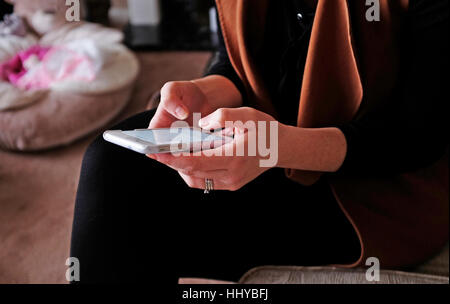 Young woman using her smart phone sending text or email message Stock Photo