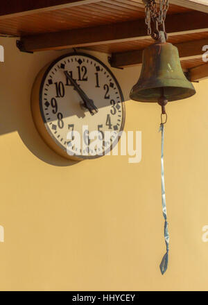 Church bell and wall clock inside monastery in Greece Stock Photo