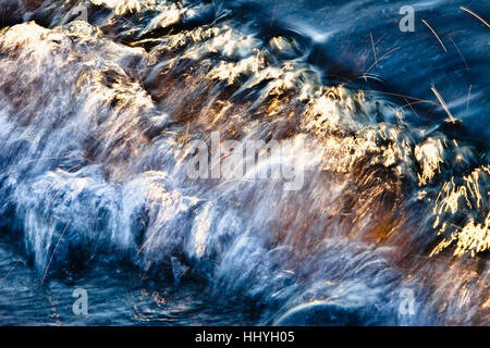 warm morning light sparkling on blue wave Stock Photo