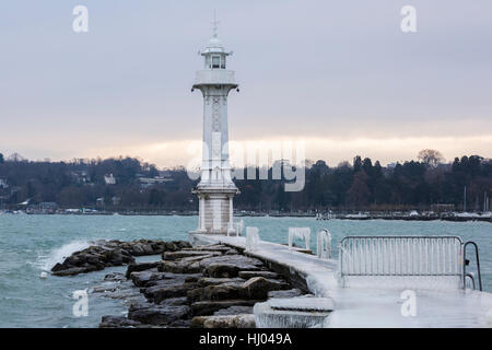 The Paquis pier and lighthouse covered with ice after a winter storm on Lake Geneva, Switzerland. Stock Photo