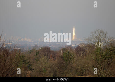 London England UK. 21st January 2017. The city of London continues to be engulfed in a layer of smog after several days low wind speed and cold temperatures. Viewed from 15 miles away at Epsom Downs in Surrey, as the afternoon sun glints off of the Shard building. Credit: Julia Gavin UK/Alamy Live News Stock Photo