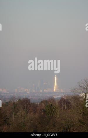London England UK. 21st January 2017. The city of London continues to be engulfed in a layer of smog after several days low wind speed and cold temperatures. Viewed from 15 miles away at Epsom Downs in Surrey, as the afternoon sun glints off of the Shard building. Credit: Julia Gavin UK/Alamy Live News Stock Photo