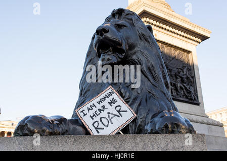 London, UK - 21 January 2017. Lion statue with protest sign below. Thousands of protesters gathered in Trafalgar Square to attend Women's March against Donald Trump calling for human rights and equality. Stock Photo