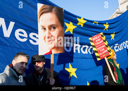 London, UK - 21 January 2017. Protesters holding Jo Cox poster and anti brexit sign standing in front of EU flag.Thousands of protesters gathered in Trafalgar Square to attend Women's March against Donald Trump calling for human rights and equality. Stock Photo