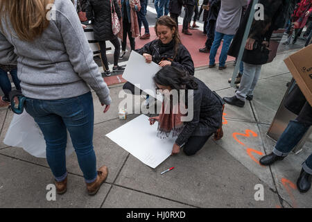 New York City, USA. 21st January,2017. Two women protesters prepare their signs for the march to Trump Tower on 5th Avenue. Credit: Simon Narborough/Alamy Live News. Stock Photo