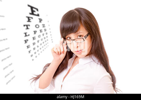 Chinese woman peering over the top of her spectacles, with eyesight test chart Stock Photo