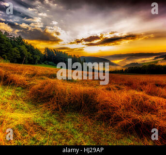 Foggy scenic glorious epic sunrise landscape panorama over valleys, fields,hills,blue sky,clouds,a view towards the horizon on a hot summer day Stock Photo