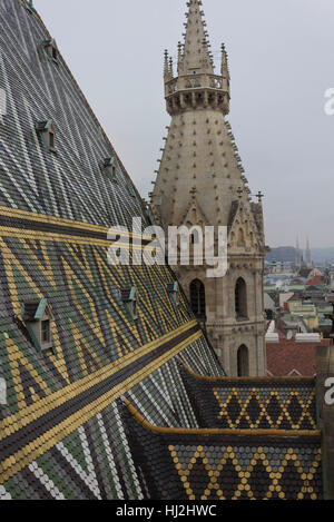 VIENNA, AUSTRIA - JANUARY 3 2016: Architectural close up of the roof and Steeple of Stephansdom cathedral from its top in Vienna, Austria Stock Photo