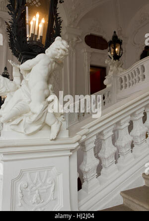 VIENNA, AUSTRIA - JANUARY 1 2016: Architectural close up of the white grand staircase of Schloss Belvedere in Vienna, with a statue in the foreground Stock Photo