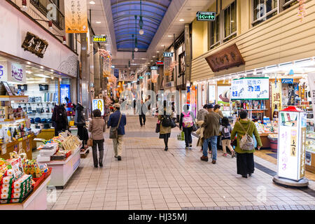 Matsuyama, Japan. The Dogo shopping arcade, known as Haikara Street, at evening time. View along modern arcade of open shops and few people walking. Stock Photo