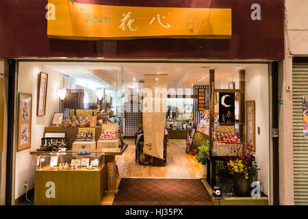 Japan, Matsuyama. Dogo shopping mall. Night time, interior. Looking into shop selling Japanese dolls and other tourist souvenirs. Stock Photo