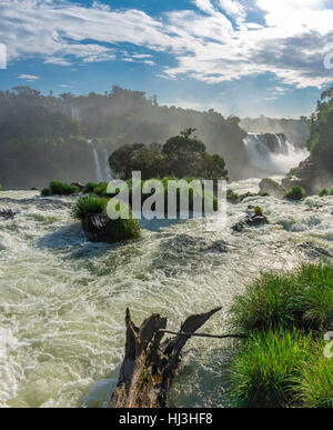 Close view of one of the Cataratas water falls under blue sky and a lot of water mist in the air at the Foz do Iguassu park, Brazil. Stock Photo