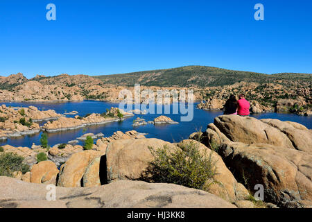 Couple sitting on rocks by Watson Lake, Prescott, Arizona, USA Stock Photo