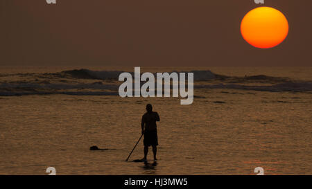 Man on a SUP during sunset over Ala Moana Beach, Honolulu, Oahu, Hawaii, USA Stock Photo