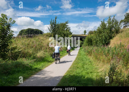 Middle aged couple cycling on the Tissington trail in the Peak District national park, Derbyshire, England. Stock Photo