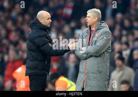 Arsenal manager Arsene Wenger (right) speaks to fourth official Anthony Taylor during the Premier League match at The Emirates Stadium, London. Stock Photo