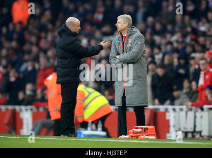 Arsenal manager Arsene Wenger (right) speaks to fourth official Anthony Taylor during the Premier League match at The Emirates Stadium, London. Stock Photo