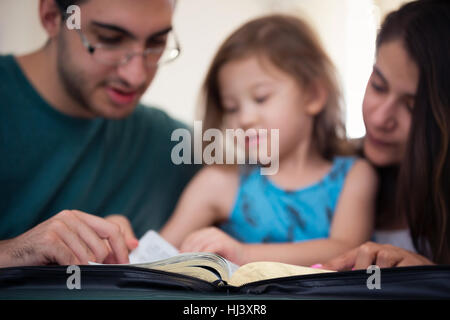 Young family studying the Word of God Stock Photo
