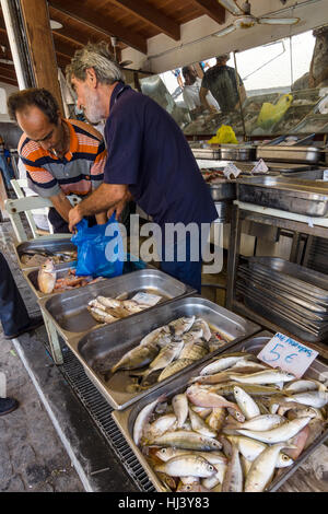 HERAKLION, GREECE - JULY 16, 2016: Crete. The buyer and the seller. Fish market in Heraklion, near the seaport. Stock Photo