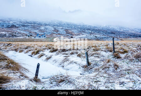 A cold, snowy scene in Iceland shows a frozen river and icy grass countryside during a winter day. Stock Photo