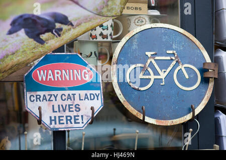 Metal sign warning 'Crazy cat lady lives here' and Bicycle sign Stock Photo