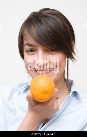 Young woman eating an orange Stock Photo