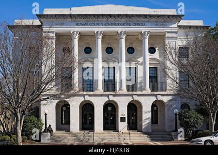 Do you notice or not see? Rown County Administrative Offices building, A man who appears to be homeless sits at the front steps. Stock Photo