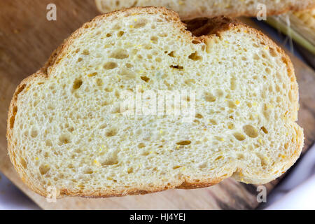 Bread made from corn on the white fabric. Slices of corn bread laying on a chopping Board Stock Photo