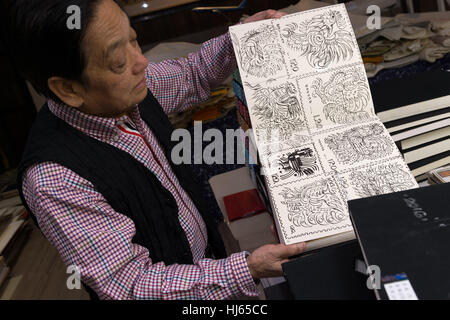 (170126) -- BEIJING, Jan. 26, 2017 (Xinhua) -- Chinese artist Han Meilin, 80, shows his sketches of roosters and hens for preparation of Chinese zodiac stamps for the upcoming Year of the Rooster at his studio in eastern district of Tongzhou in Beijing, capital of China, Jan. 24, 2017. Han, designer of the 2008 Beijing Olympic Games mascot 'Fuwa,' has just finished the design of Chinese zodiac stamps for the upcoming Year of the Rooster. The set of Chinese Lunar New Year rooster stamps, issued earlier this month, contain two items showing a rooster striding proudly and a hen looking after her Stock Photo