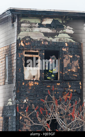 Fitchburg, Massachusetts, USA. 26th Jan, 2017. A Fitchburg, Mass firefighter assesses damage to the so-called 'Trump House' at 19-21 West St in Fitchburg Mass. after the second fire in a month damaged the rear of the building. A fire on December 22nd was deemed accidental due to smoking materials in an outside couch. The building was unoccupied at the time of this morning's fire which was reported around 6:00 am. Credit: Jim Marabello/ Alamy Live News Stock Photo